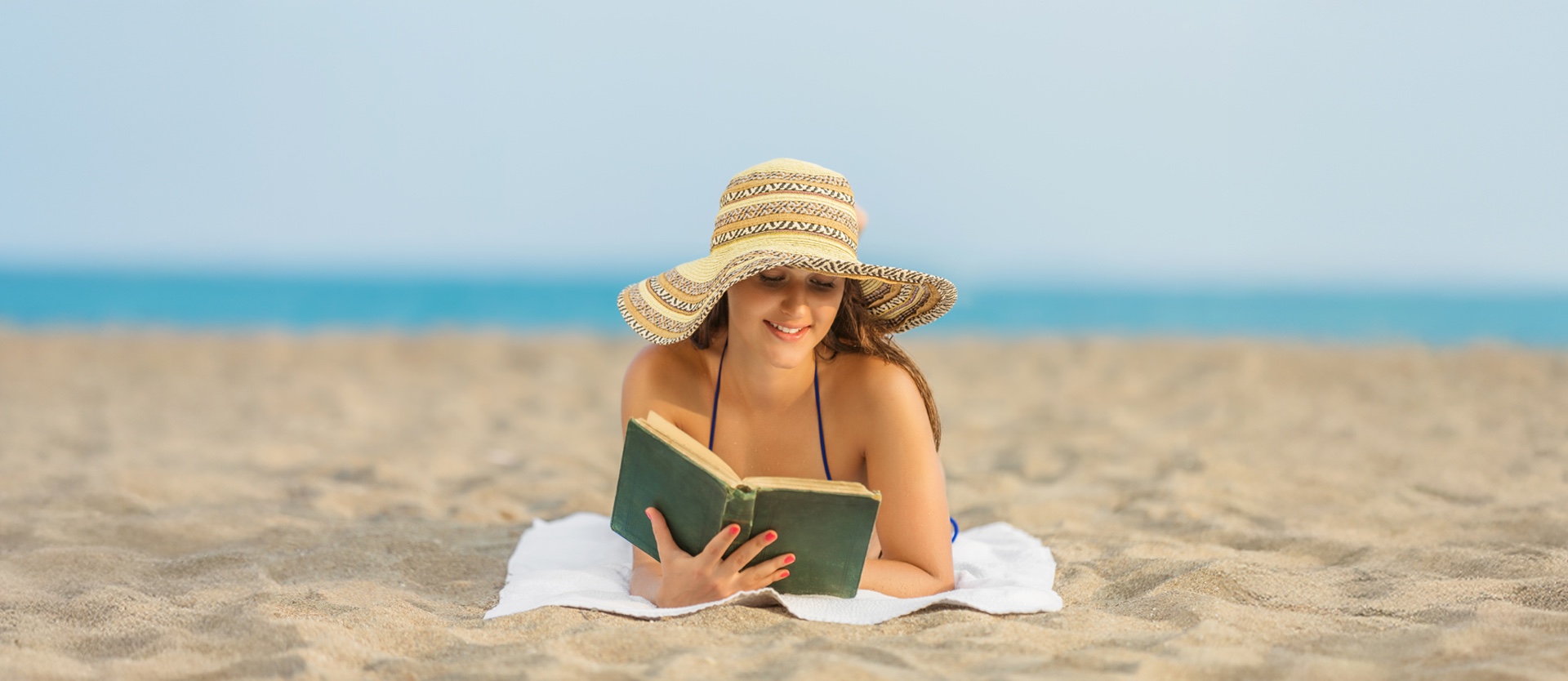 Woman reading book on the beach