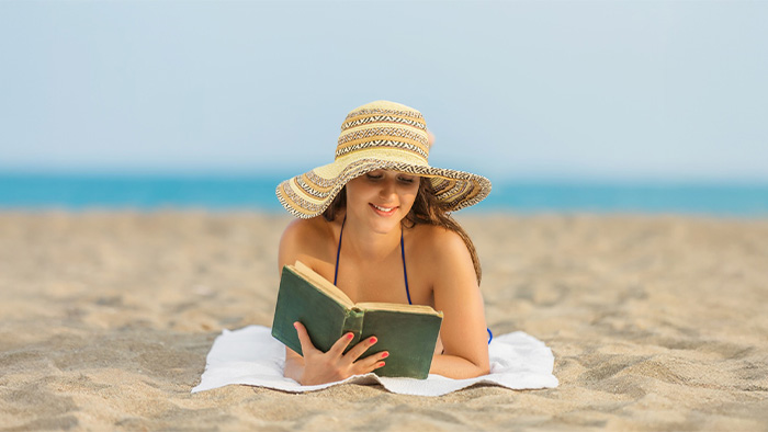 Woman reading book on the beach