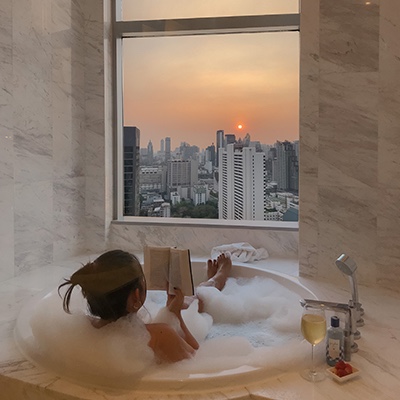 Woman reading a book in the tub of her high rise apartment