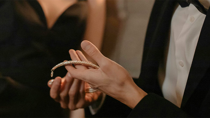 Well-dressed man holding necklace