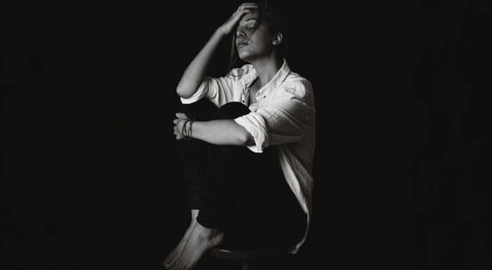 Woman on stool with dark background