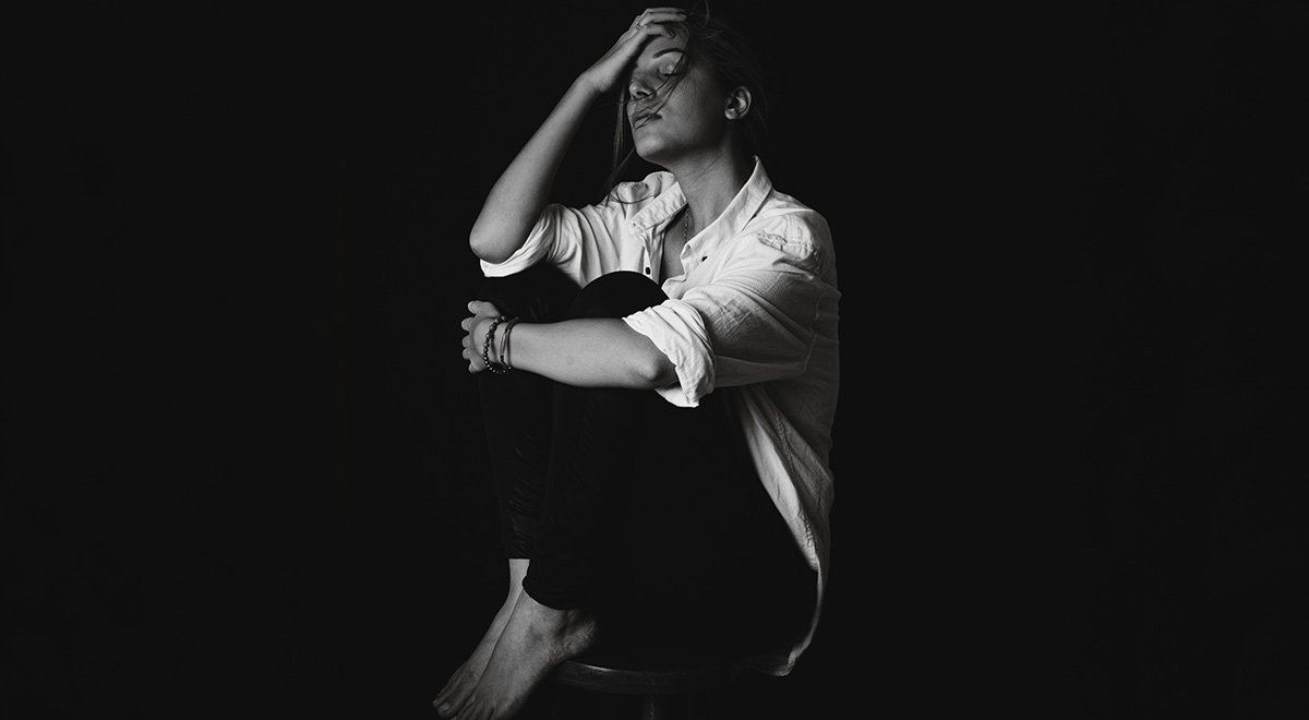 Woman on stool with dark background