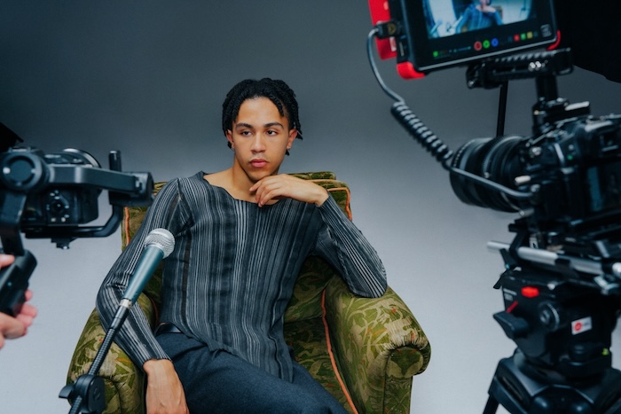 Influencer sitting in chair in front of several recording devices