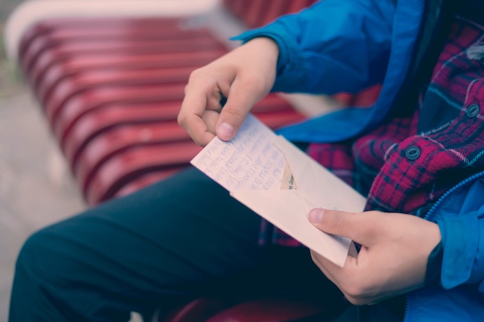 Man opening a letter with handwritten note