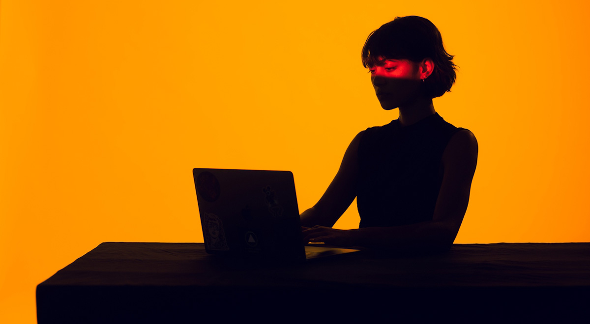 Silhouetted woman on computer talking with AI